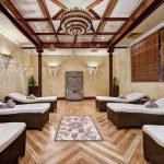Hotel relaxation room with loungers, wood detailing and a chandelier