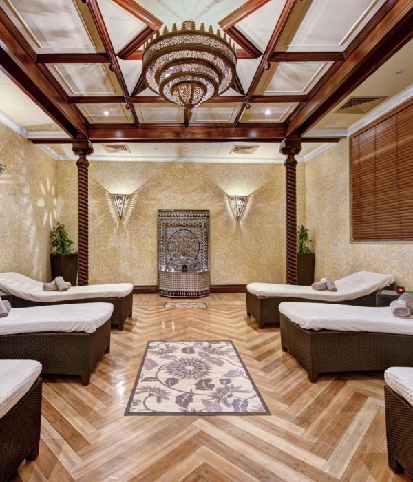Hotel relaxation room with loungers, wood detailing and a chandelier